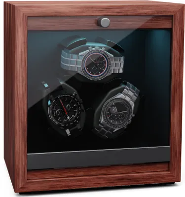 A watch winder with three watches inside, displayed in a wooden case with a glass door.