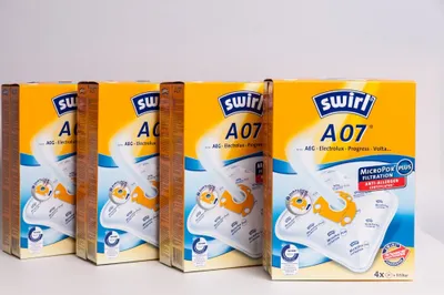 Four boxes of Swirl vacuum cleaner bags are lined up on a white surface against a white background.
