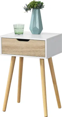 A white and wood-tone side table with a drawer, a glass of water, and a vase with greenery on top.