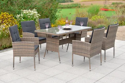 An outdoor patio set with a table and chairs, set in a garden.