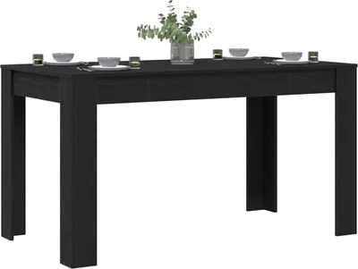 A black dining table set with place settings and a vase of flowers.