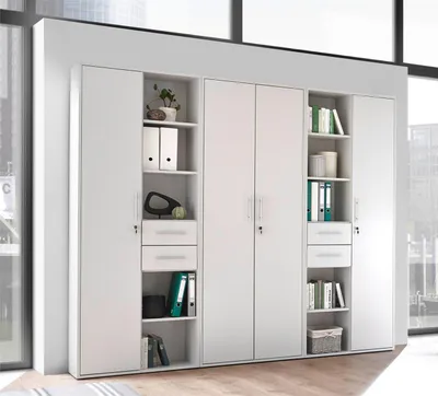 A white modular shelving and storage unit with multiple doors and open shelves, set against a blurred office background.