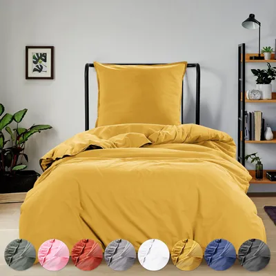 A bed with yellow bedding is shown in a room with a plant and a bookshelf.