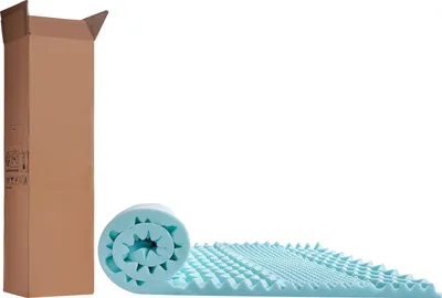 A rolled-up light blue mattress topper is shown next to a tall, open cardboard box on a white background.