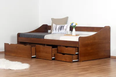 A wooden daybed with drawers, set against a plain wall.