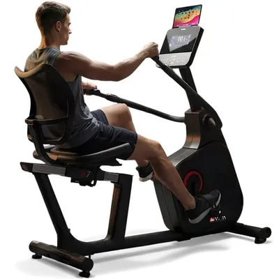 A man is using a recumbent exercise bike.