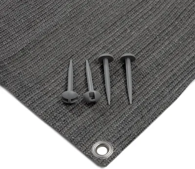 A close-up view of a gray fabric product with several plastic stakes and a metal grommet.