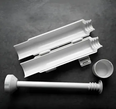 A white sushi-making tool set is laid out on a dark gray surface.