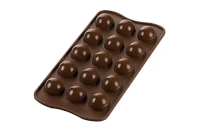A brown silicone chocolate mold filled with chocolate candies.