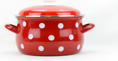 A red enamel pot with white polka dots is shown against a white background.
