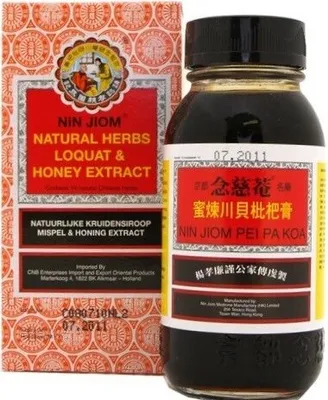 A bottle of Nin Jiom Pei Pa Koa herbal syrup and its packaging are shown against a white background.