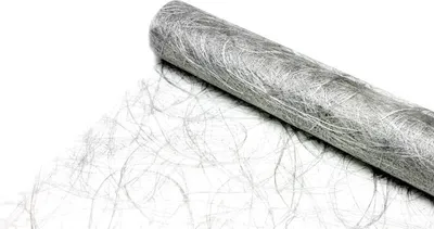 A roll of silver decorative fabric, likely a table runner, is shown against a white background. Some of the fabric is unrolled, revealing its textured, fibrous nature.