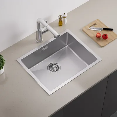 A stainless steel kitchen sink with a faucet on a countertop.