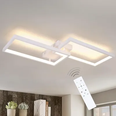 A modern white LED ceiling light fixture with a remote control shown in the foreground, against a white ceiling.