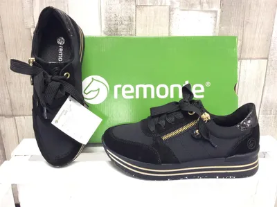 A pair of black Remonte sneakers with gold accents are displayed next to their green packaging box.
