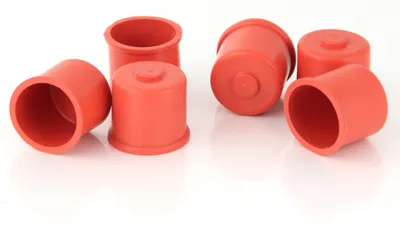 A group of red rubber caps on a white background.