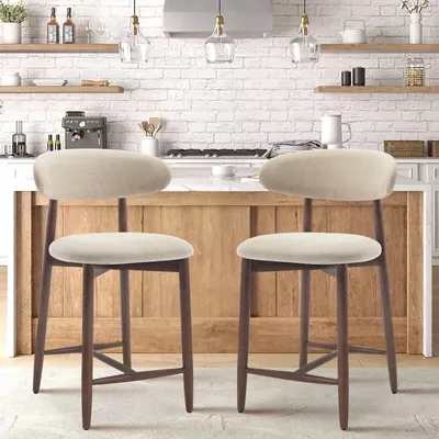 Two bar stools are placed in a kitchen setting, in front of a kitchen island and stove.