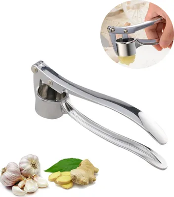 A close-up of a stainless steel garlic press with garlic and ginger in the foreground. A small inset image shows the garlic press in use.