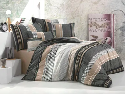 A bedroom scene with a bed dressed in bedding.