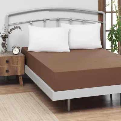 A bed with a brown fitted sheet and two white pillows.