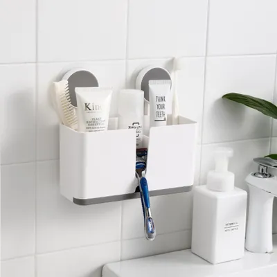 A bathroom organizer with toothbrushes, toothpaste, and a razor attached to a tiled wall.