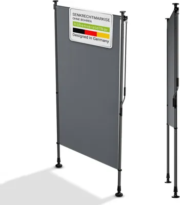 A grey vertical awning or screen is shown standing on a white background with its shadow cast to the left. A small sign with text and the German flag is attached to the top left of the screen.