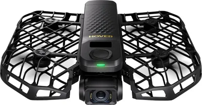 A black drone with protective cages around its propellers and a camera at the front, set against a white background.