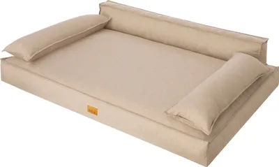 A beige dog bed with bolster pillows on a white background.