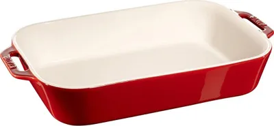 A red ceramic baking dish with white interior, shown from a slightly elevated side angle on a white background.