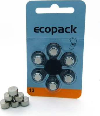 A product shot of hearing aid batteries in packaging, with some loose batteries in the foreground.