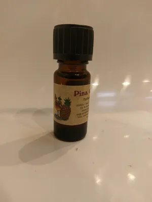 Kleine braune Flasche mit einem schwarzen Verschluss. Auf dem Etikett steht "Pinacolada".