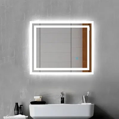 A modern bathroom vanity with a sink, faucet, and a lit LED mirror mounted on a textured gray wall.