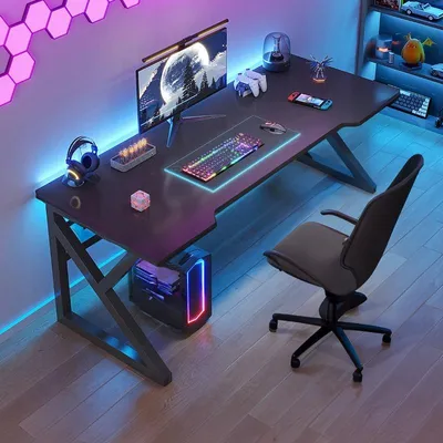 A modern gaming desk setup with a computer, monitor, keyboard, and accessories, illuminated by colorful LED lighting.