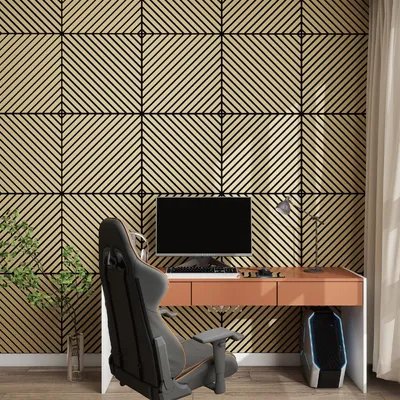 A gaming setup with a desk, chair, computer, and a plant against a patterned wall.