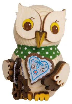 Eine niedliche Eule aus Holz trägt ein grünes Halstuch mit weißen Punkten und hält ein Lebkuchenherz mit blauer Verzierung in ihren Flügeln