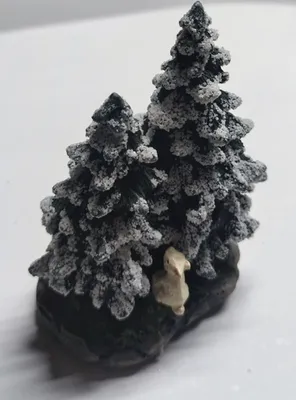 Detailreiche Darstellung von zwei schneebedeckten Tannen auf einem felsigen Untergrund.