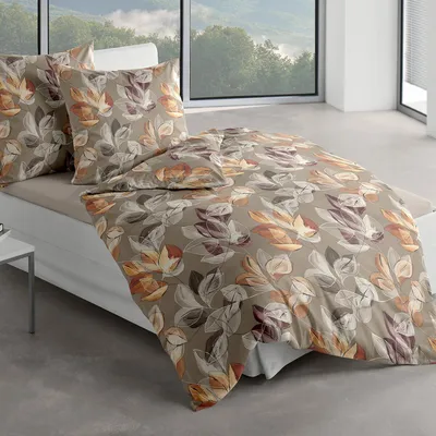 A bed with bedding set in a room with a large window overlooking a landscape.