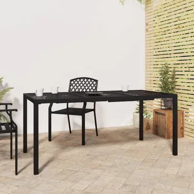 An outdoor patio scene with a black metal table and chairs set up on a tiled floor, with a wooden slatted screen and plants in the background.