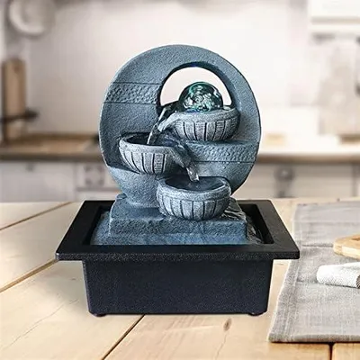 Produktbild von Moderner, minimalistischer Tischbrunnen mit fließendem Wasser als Dekoration für Wohnzimmer und Wohnzimmer, dessen kreative Form an einen Zen-Meditationsbrunnen erinnert
