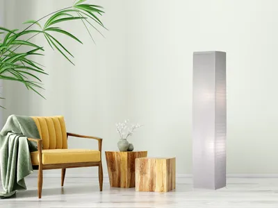A minimalist living room scene with a yellow armchair, wooden side tables, a plant, and a white floor lamp.