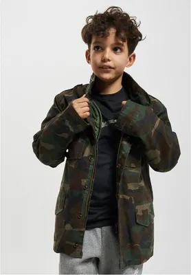 A young boy is wearing a camouflage jacket.
