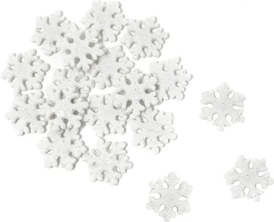 A collection of white glittery snowflake decorations scattered on a white background.