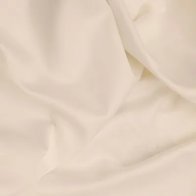 A close-up shot of creased cream-colored fabric, likely a bedsheet.