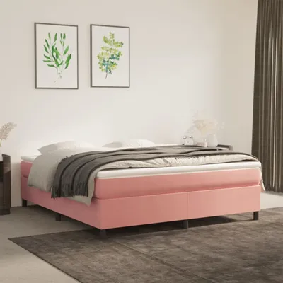 A pink upholstered bed with white bedding and a gray throw blanket is shown in a bedroom setting.