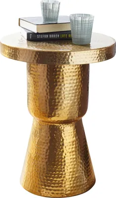 Runder Beistelltisch mit gehämmerter Metalloberfläche in Gold und weißer Einlage, beladen mit Büchern und Gläsern.