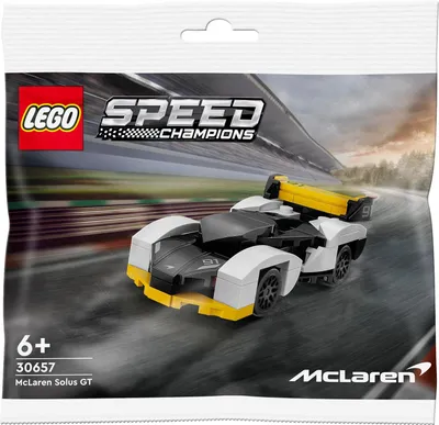 A LEGO Speed Champions McLaren Solus GT polybag on a blurred racetrack background.
