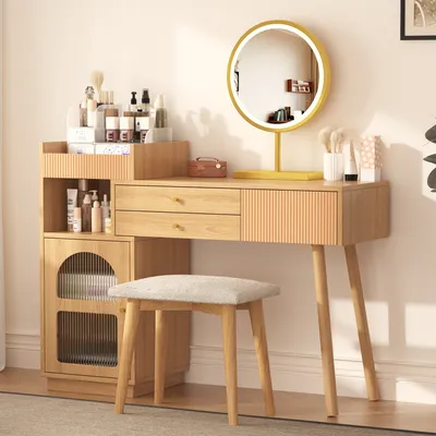 A vanity table with a mirror, drawers, and a side cabinet, along with a stool, set up in a room.