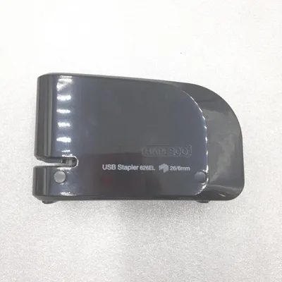 A black electric stapler is shown from a top-down perspective on a light gray and white surface.