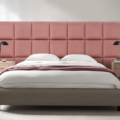 A bedroom scene with a bed and a pink upholstered headboard.