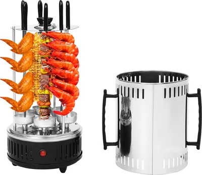 A vertical electric grill with food on skewers and a charcoal chimney starter.